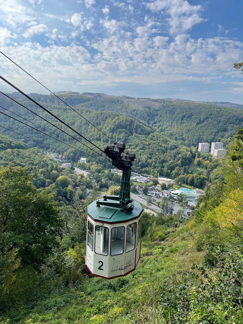 Kabine der Burgberg-Seilbahn über dem Kurort Bad Harzburg, dahinter bewaldete Harzhügel